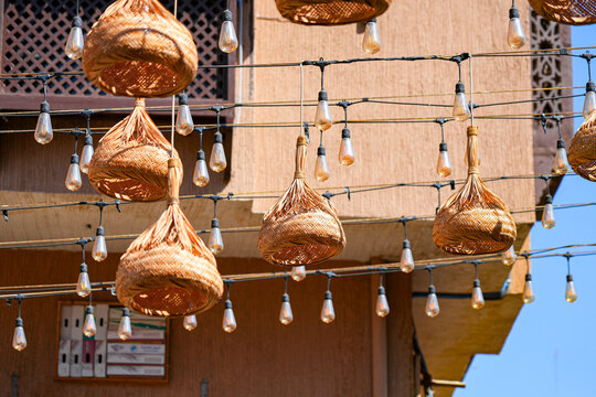 Traditional wicker ornaments and hanging light bulbs over a street in Al Balad district of Taif, Saudi Arabia