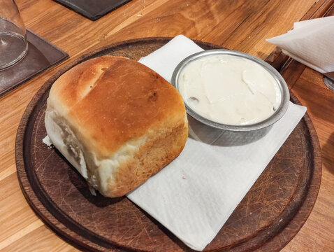 Rustic homemade bread with garlic cream on wooden board