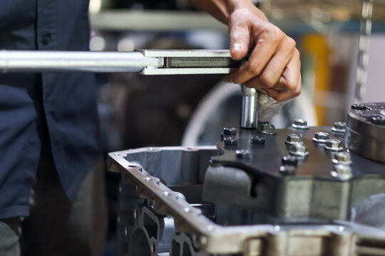Mechanic Hands Using Torque Wrench on Engine Block