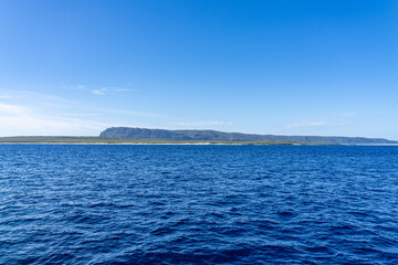 Fototapeta premium Niʻihau & Nāpali Coast Boat Tour. Kauai County, Hawaii, Pacific Ocean. In the distance is Niihau, is the seventh largest island in Hawaii and the westernmost of the main islands. 