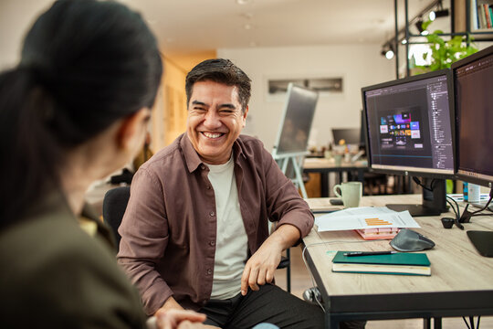 Smiling designer chatting with colleague in modern office