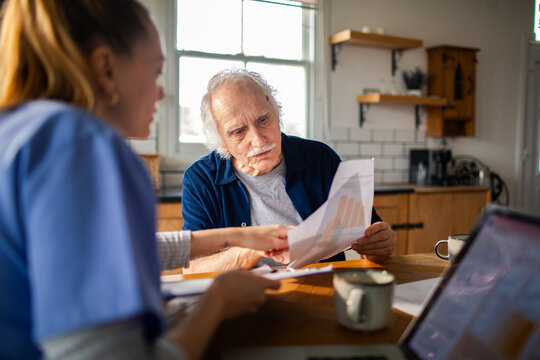 Nurse helps senior man review documents at home