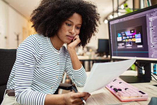 Woman designer reviewing mockup at computer in modern office