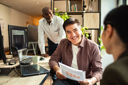 Diverse coworkers reviewing data in modern office