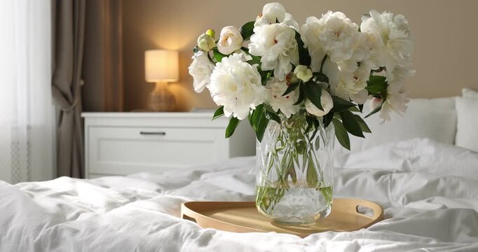 Bouquet of beautiful peony flowers on bed at home