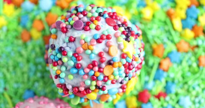 Two tasty cake pops on sprinkles, top view. Camera moving up