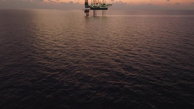 Aerial view of offshore jack up rig and offshore platform during sunset for oil and gas exploration and production. 