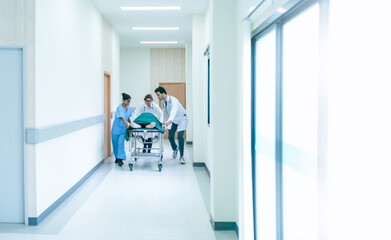 Obraz premium Doctor team and nurse staff carrying stretcher with patient from the accident ambulance running to the surgery room in hospital