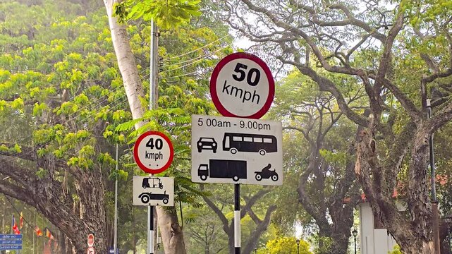 Slow motion sunshower rain falling on city street with speed limit signs, Colombo - Sri Lanka.