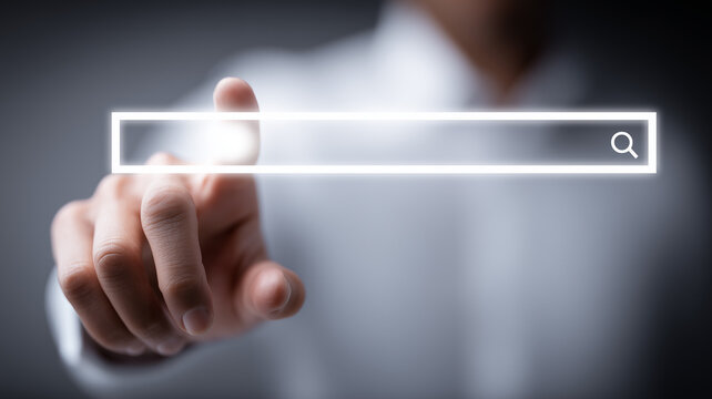 A hand touching a digital search bar with magnifying icon, representing online search, information discovery and user interaction with web technology.
