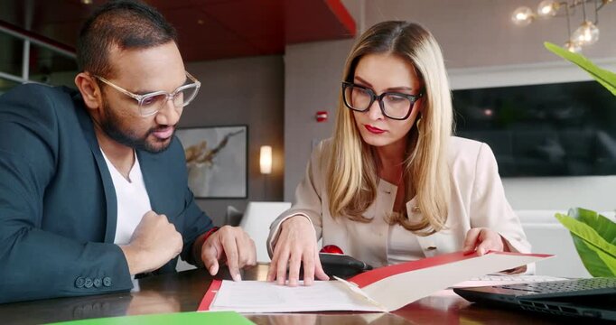 Coworkers Male and Female Analyzing Financial Reports and Documents in Office