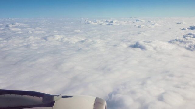 Beautiful white clouds and blue sky viewed from airplane window, 4k real time footage travel concept, b roll shot.