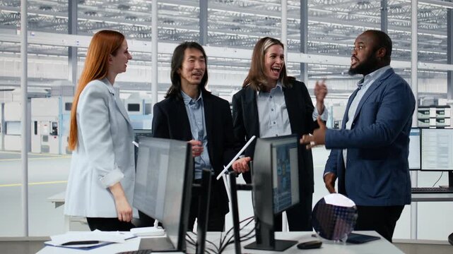 Happy diverse engineering team in microchip factory office celebrate project completion, achieving milestones, cheerful colleagues excited by scientific breakthrough in semiconductor lab.