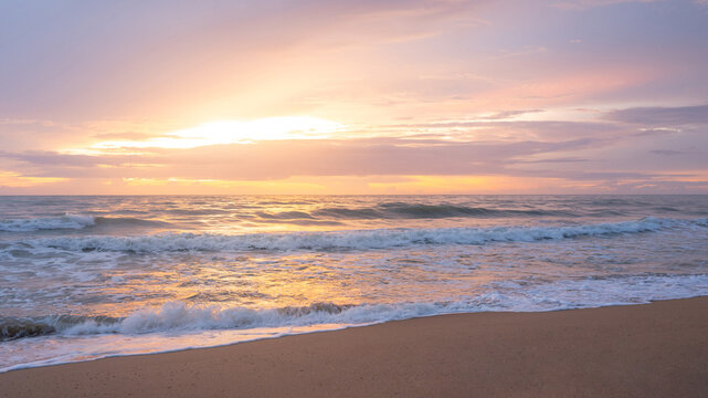 Beautiful sunset landscape on tropical beach island. Golden sea waves reach the shoreline during sundown. Summertime holiday travel in Thailand. Summer vacation background