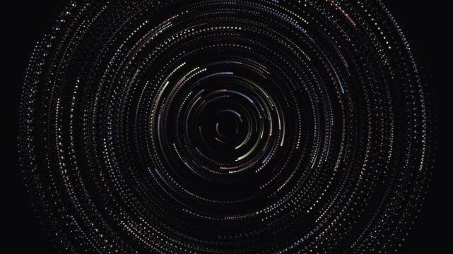 Abstract particle data swirl animation with colorful dots forming concentric rotating circles on a dark background, representing technology, science, and digital information flow.