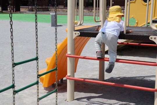 公園の遊具やアスレチックで遊ぶ幼児の姿。挑戦する気持ちや好奇心、運動能力の発達をイメージした写真素材。