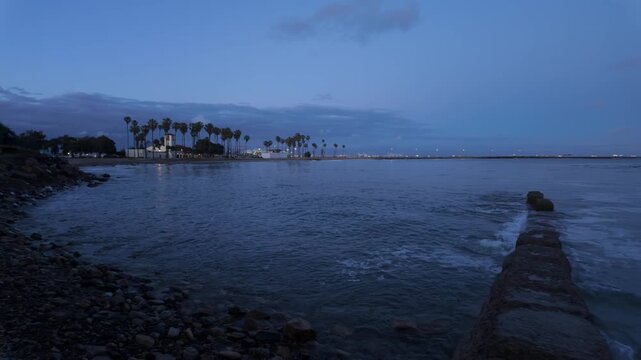 Gimbal wide panning shot of Cabrillo Beach with the Port of Los Angeles at dusk in Southern California. 4K