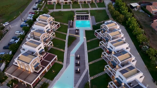 High angle aerial view of modern luxury villa blocks with solar panels, private lawns and terraces at Thalassa Suites resort in Acharavi, North Corfu, Greece