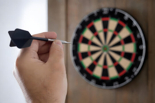 Hand Aiming Dart Toward Dartboard