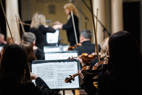 Symphony orchestra musician playing violin close up on stage