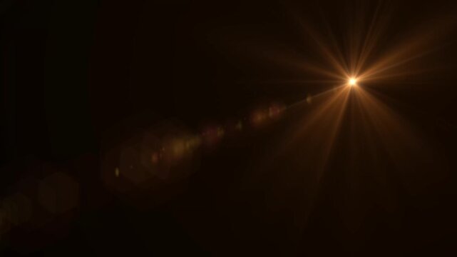 Abstract bright light burst with optical lens flare,Bright explosion of fire and light in a starry night sky with a optical lens flare.