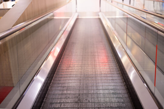 Empty escalator in contemporary building with polished surfaces