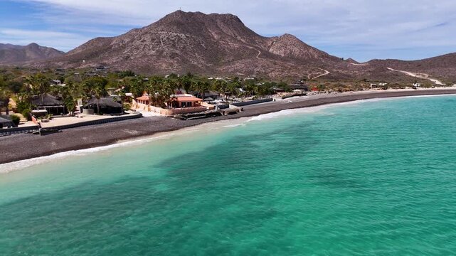 Drone Flight Over Beachfront Eco Resorts and Turquoise Sea in Cabo Pulmo, Baja Californania Sur, Mexico, Horizontal Backwards drone shot in a sunny day
