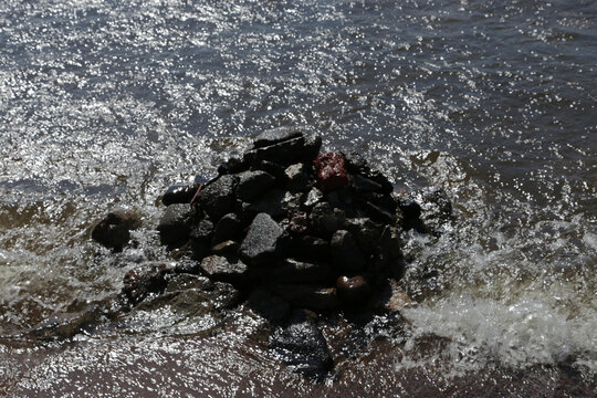 Rocks jut from churning, sunlit water
