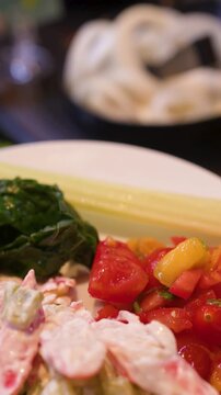 Person Using Tongs to Serve Fresh Celery at a Salad Bar