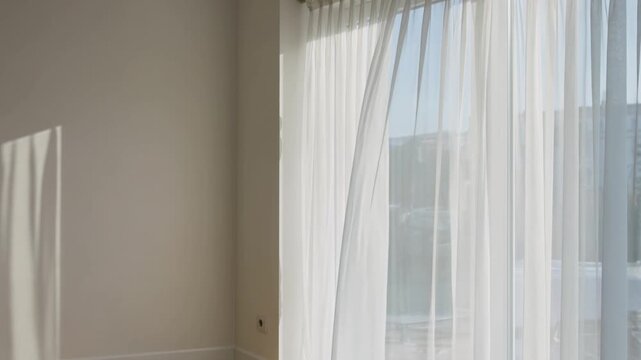 柔らかな夏の朝日が白いシアーカーテンを通して室内に差し込むライフスタイル映像です。
風によってゆっくりと揺れる布の動きが穏やかで心地よい空間を演出します。