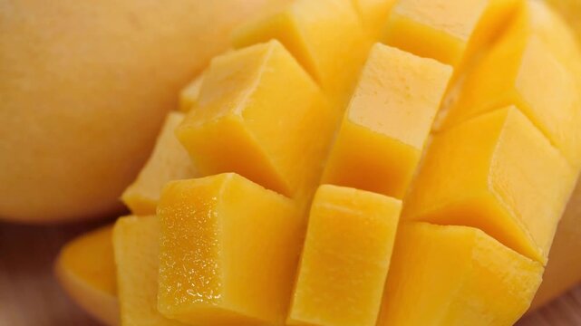 Fresh yellow mango cubes close up, ripe tropical mango fruit sliced in hedgehog style, juicy organic mango pieces for healthy dessert