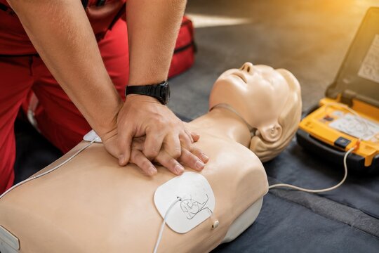 Closeup of a person performing cpr on a medical training mannequin