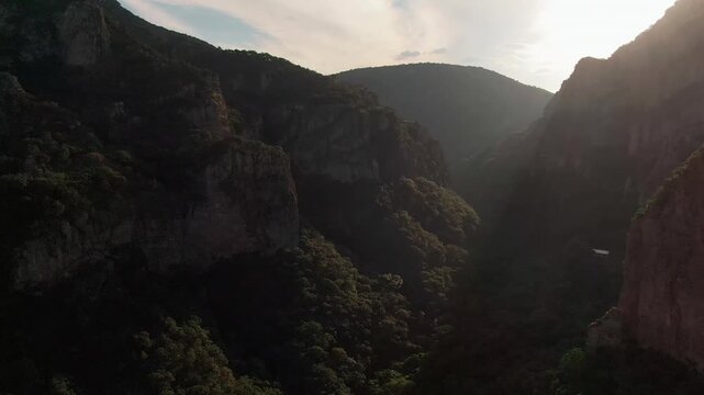 La Garita Canyon with towering rocky cliffs, dense vegetation, rugged canyon walls, and warm sunset light filtering through the landscape near Sierra P&eacute;njamo, Guanajuato, Mexico.