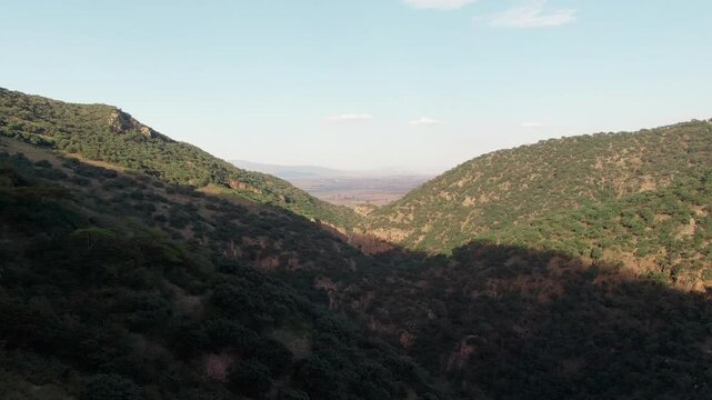 La Garita Canyon static aerial view of canyon slopes, vegetation, shadows, and distant landscape in Guanajuato
