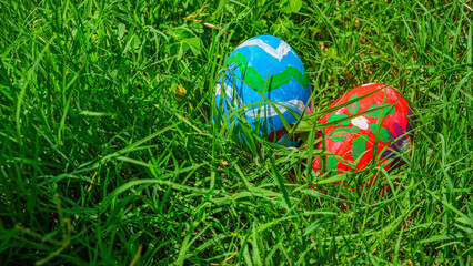 Fototapeta premium Colorful Painted Easter Eggs Hidden in Lush Green Grass