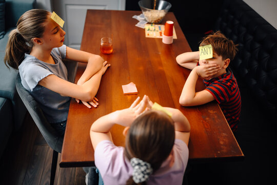 Children playing guessing game with sticky notes