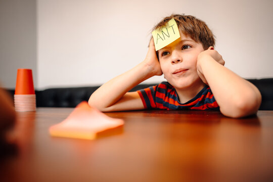 Young boy playing guessing game with sticky note