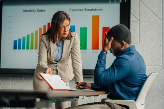 Boss scolding employee during a performance review meeting