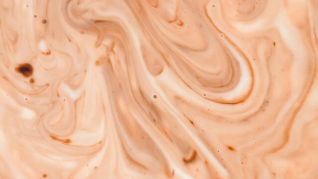 The abstract background is a swirl of chocolate and milk cream, creating a warm, marbled liquid texture