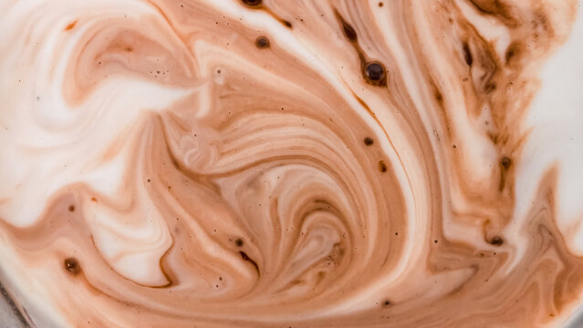 A close-up abstract image of chocolate milk swirling together creating a beautiful marble-like liquid pattern