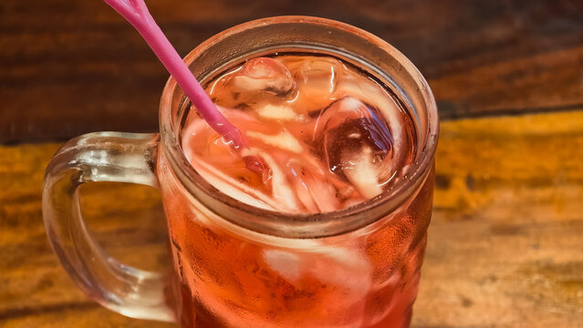 Refreshing Iced Cantaloupe Drink in a Mason Jar with a Pink Straw on a Rustic Wooden Table