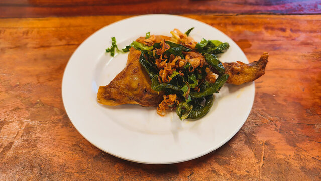 Acehnese style chicken dish with toppings of chopped green chilies and saut&eacute;ed pandan leaves.