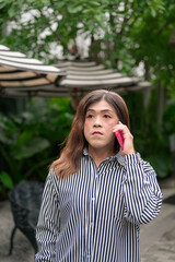 Fototapeta premium Thai Isan transgender woman calling with pink phone