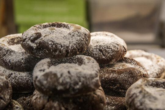 Primer plano de una pila de bollos tiernos de chocolate cubiertos con az&uacute;car en polvo en una pasteler&iacute;a. Boller&iacute;a tradicional reci&eacute;n horneada para el desayuno o la merienda.