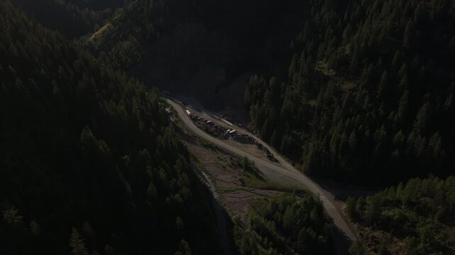 Aerial of forest road through Shoshone County Idaho in Coeur Dalene forest winding through dense evergreen trees in the summer