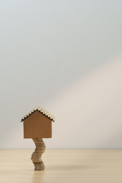 Real estate investment concept with cardboard house on stack of coins