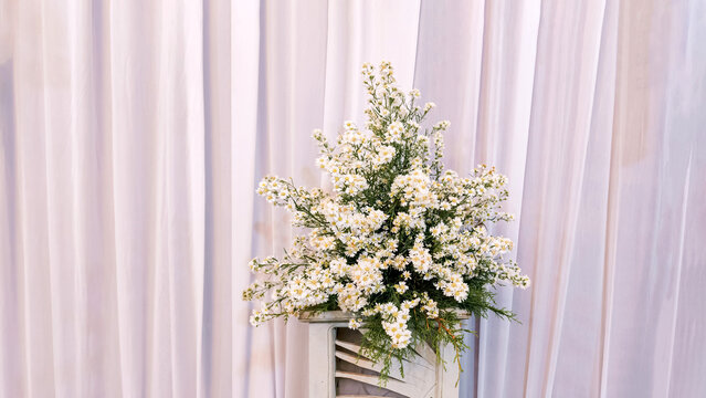 Elegant White Flower Bouquet Arrangement Displayed Against Soft Draped Fabric Backdrop for Wedding Decor