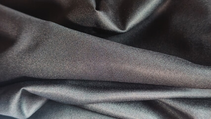 Fototapeta premium Smooth Black Satin Fabric Texture Background featuring Elegant Folds and Luxurious Shimmering Surface Detail for Textile Design