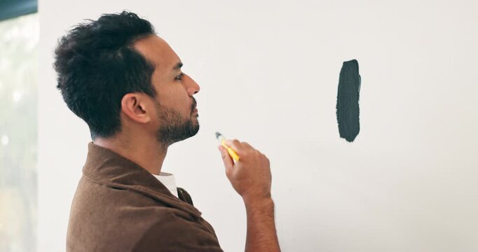Brush, painting and thinking with man in house for diy project or renovation decision. Choice, color and considering with serious person in apartment for home improvement, makeover or upgrade