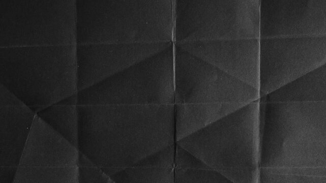 Folded Black Paper with Geometric Shadow Patterns abstract